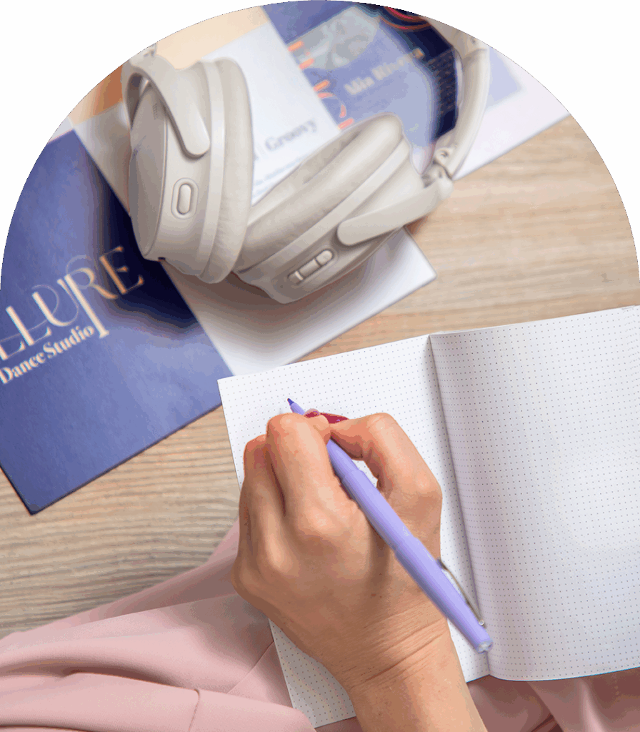 Wireless headphones on notebook with hand writing, image for Andrews Artistry SEO.