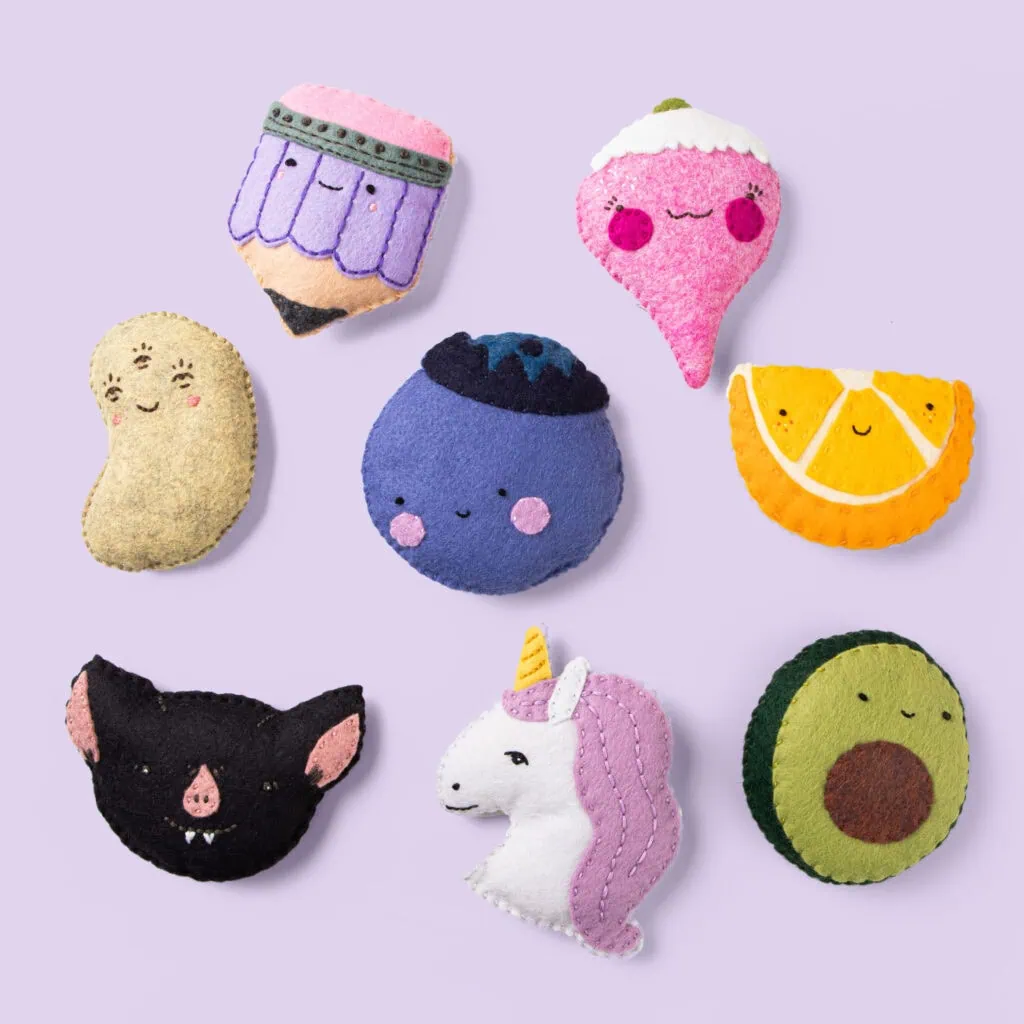 Colorful felt plushies with cute fruit, animal, and fantasy character designs for decor or gifts.