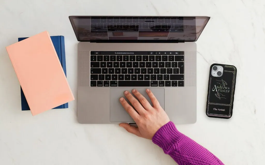 Laptop with hand on trackpad for digital art and design inspiration.